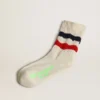 Chaussettes en coton blanc à l’aspect vieilli, avec des rayures rouges et bleu marine