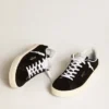 Chaussures de tennis pour femme en daim noir avec languette de talon en cuir blanc