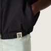 Gilet pour homme en sergé de coton bleu foncé avec fermeture à glissière et étiquette imprimée d’un drapeau