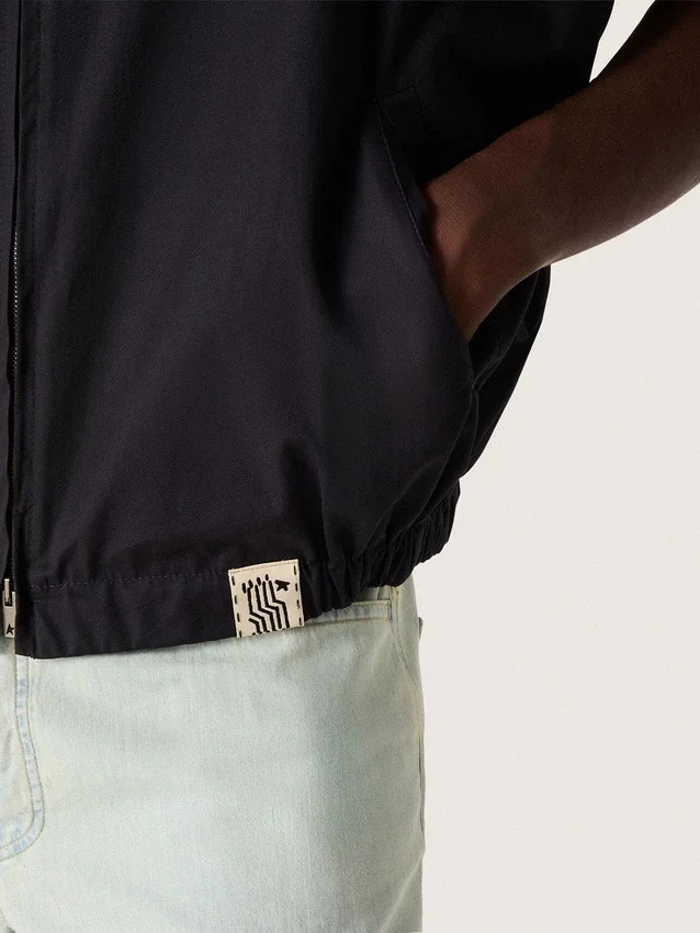 Gilet pour homme en sergé de coton bleu foncé avec fermeture à glissière et étiquette imprimée d’un drapeau