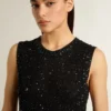 Haut en maille noire avec paillettes et détails contrastés