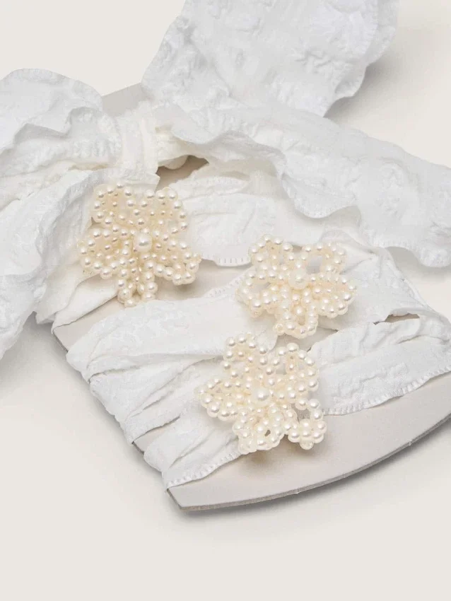 Lacets blancs froissés « Peaux » avec des applications de perles en forme de fleurs