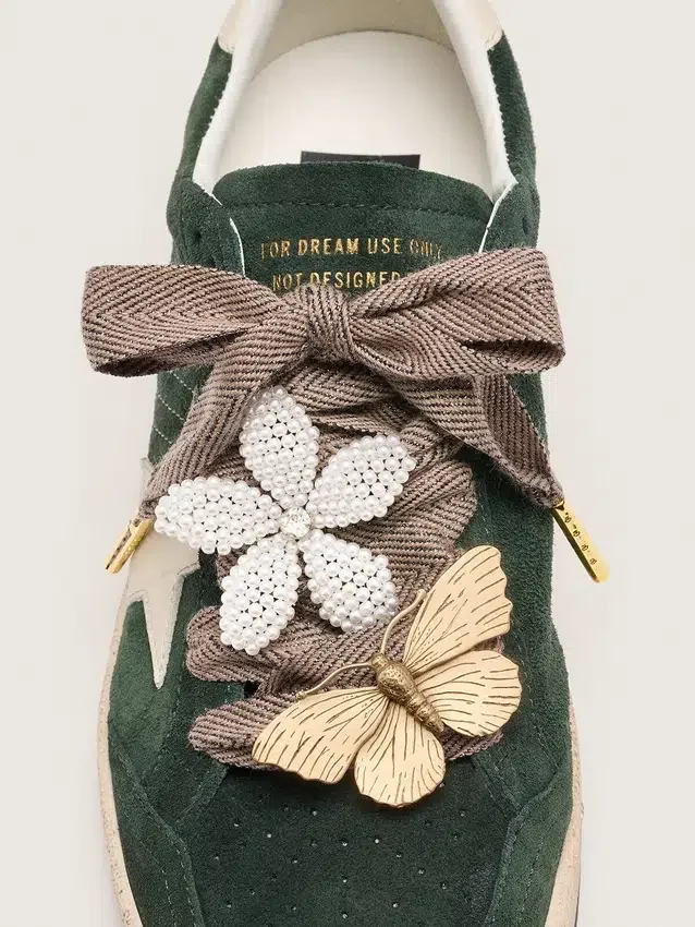 Lacets « Sparkling » marron, noirs et argentés à motif chevrons avec deux breloques appliquées