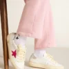 May Young avec une étoile pailletée fuchsia et une languette de talon en cuir métallisé