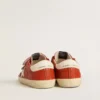 Modèle Junior Old School en nappa orange avec une étoile blanche et une languette de talon en cuir couleur crème