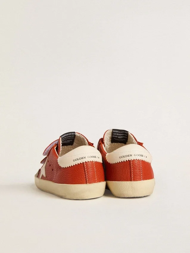 Modèle Junior Old School en nappa orange avec une étoile blanche et une languette de talon en cuir couleur crème