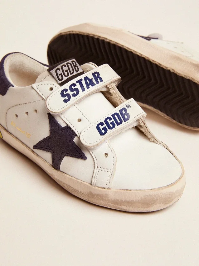 Modèle « Old School Young » en cuir blanc, avec une étoile en daim bleu et une languette au talon