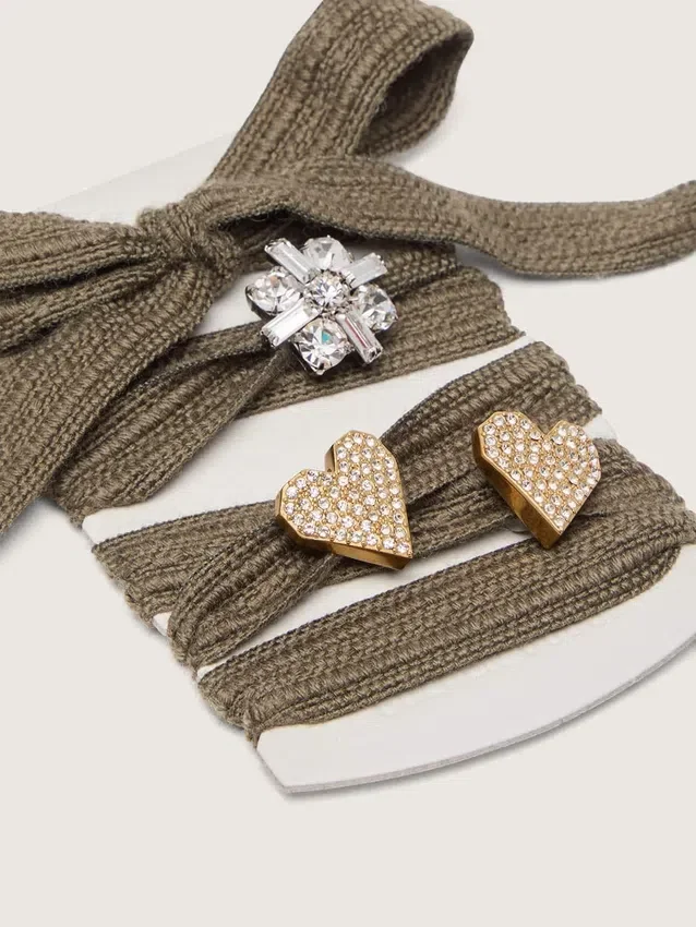 « Peaux » en laine vert sauge avec trois appliqués en pierres précieuses