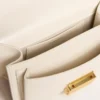 Petit sac Venezia en cuir gaufré couleur beurre avec écharpe tressée et double breloque