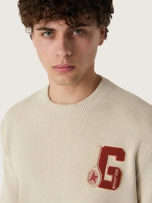 Pull unisexe à col rond en coton beige, avec un patch sur le devant et un logo dans le dos