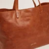 Sac Pasadena en cuir martelé brillant couleur beige clair avec logo doré sur le devant