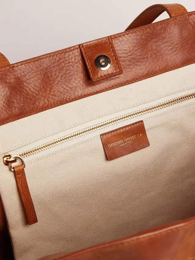 Sac Pasadena en cuir martelé brillant couleur beige clair avec logo doré sur le devant