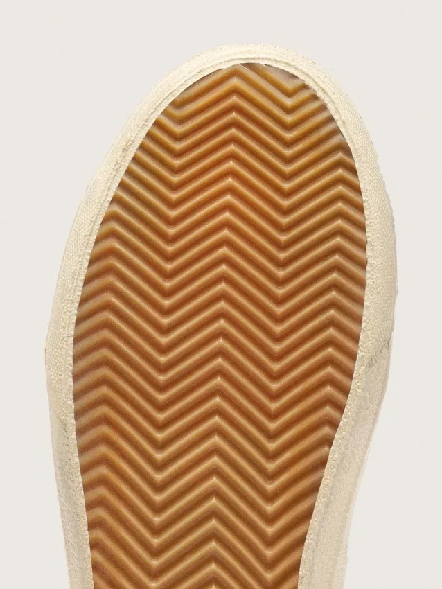 Slide beiges ornées d’une étoile en cuir métallisé rose et d’un détail brillant