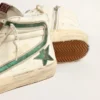 Slide en nappa beige ornée d’une étoile et d’un flash en cuir laminé vert