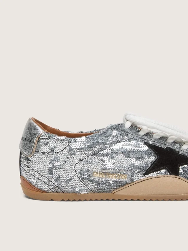 Modèle True-Star pour femme, en paillettes argentées avec une étoile noire et une languette de talon en cuir argenté